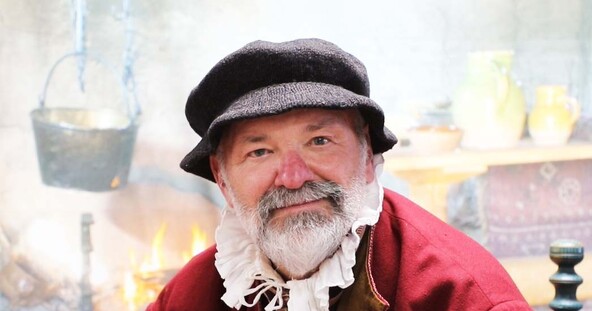 Man in Pilgrim Dress In Front of hearth