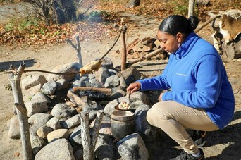 Museum educator cooks over a fire at the Historic Patuxet Homesite