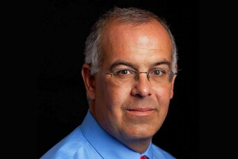Man in blue shirt with red tie and glasses
