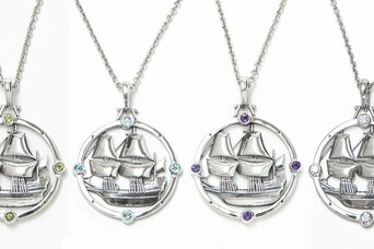 Four silver pendants with tall ship in center