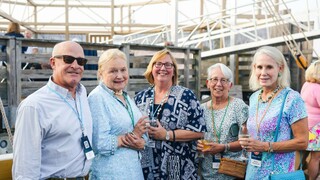 Group of four woman and one man posed on dock