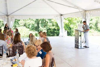 Seated guests at a business conference listen to a speaker