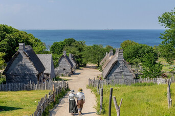 Pilgrim couple walking down path in 17th-Century English Village