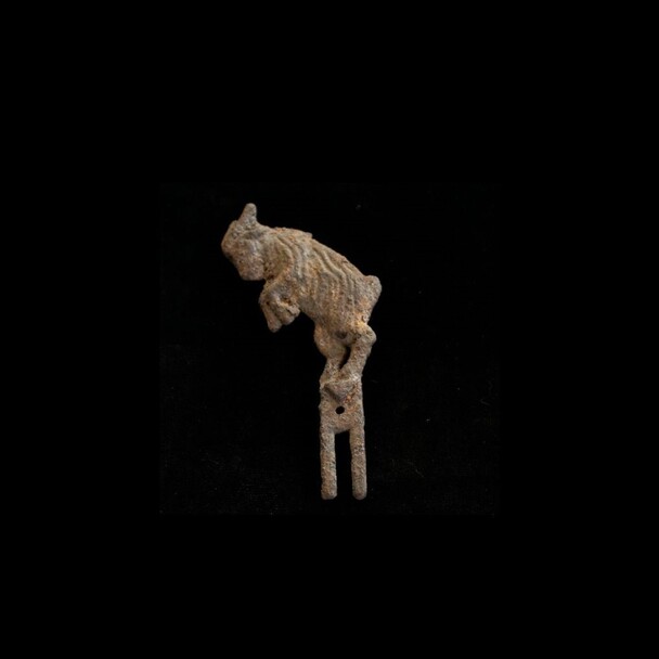 Ram Figurine uncovered from the RM Site. The piece depicts a leaping ram with two prongs at the bottom.