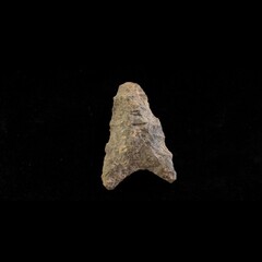 Triangular shaped projectile point made of grey stone
