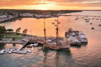 Ariel view of Mayflower II docked in downtown Plymouth at sunset