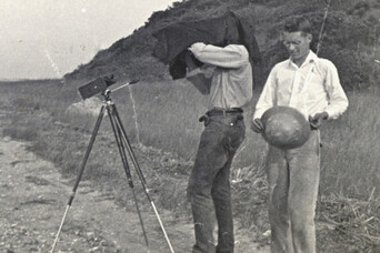 Two men conduct archeology work in a field
