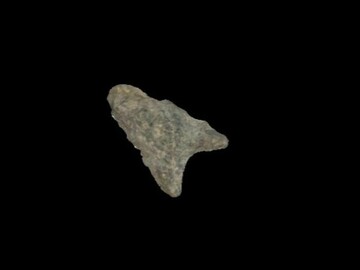 Triangular spear point made of grey rhyolite with a deeply concave base