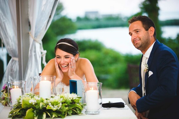 Wedding couple seated before a table arrangement laugh
