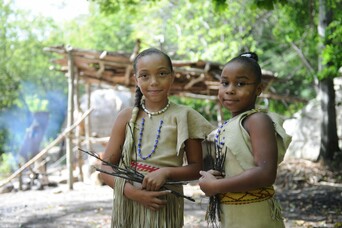 Two young Wampanoag girls on the Historic Patuxet Homesite wearing Wampanoag regalia
