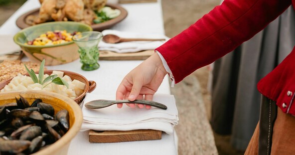 Pilgrim woman sets table for a Harvest Feast