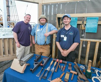 Mayflower II crew poses with guest on exhibit dock.