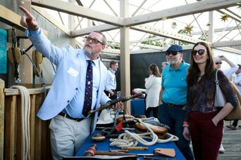 Captain Whit Perry of Mayflower II presents shipwright's tools to guest on exhibit dock.