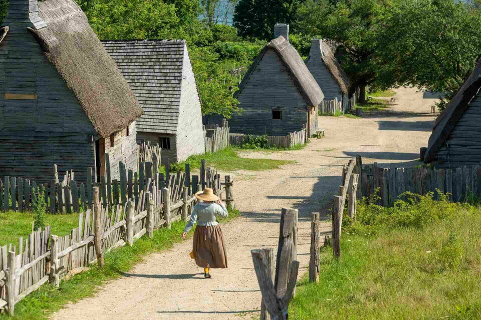 Pilgrim woman walking down path in village