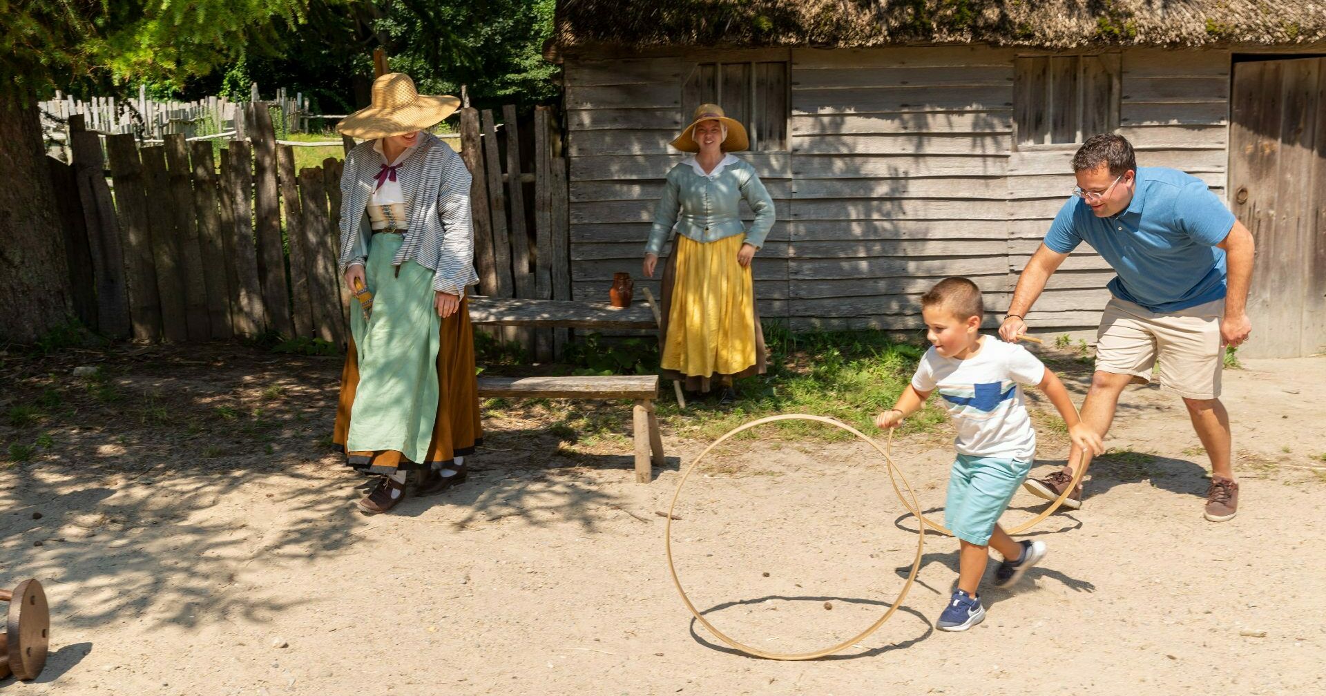Father and son spin hoops with Pilgrims in English Village