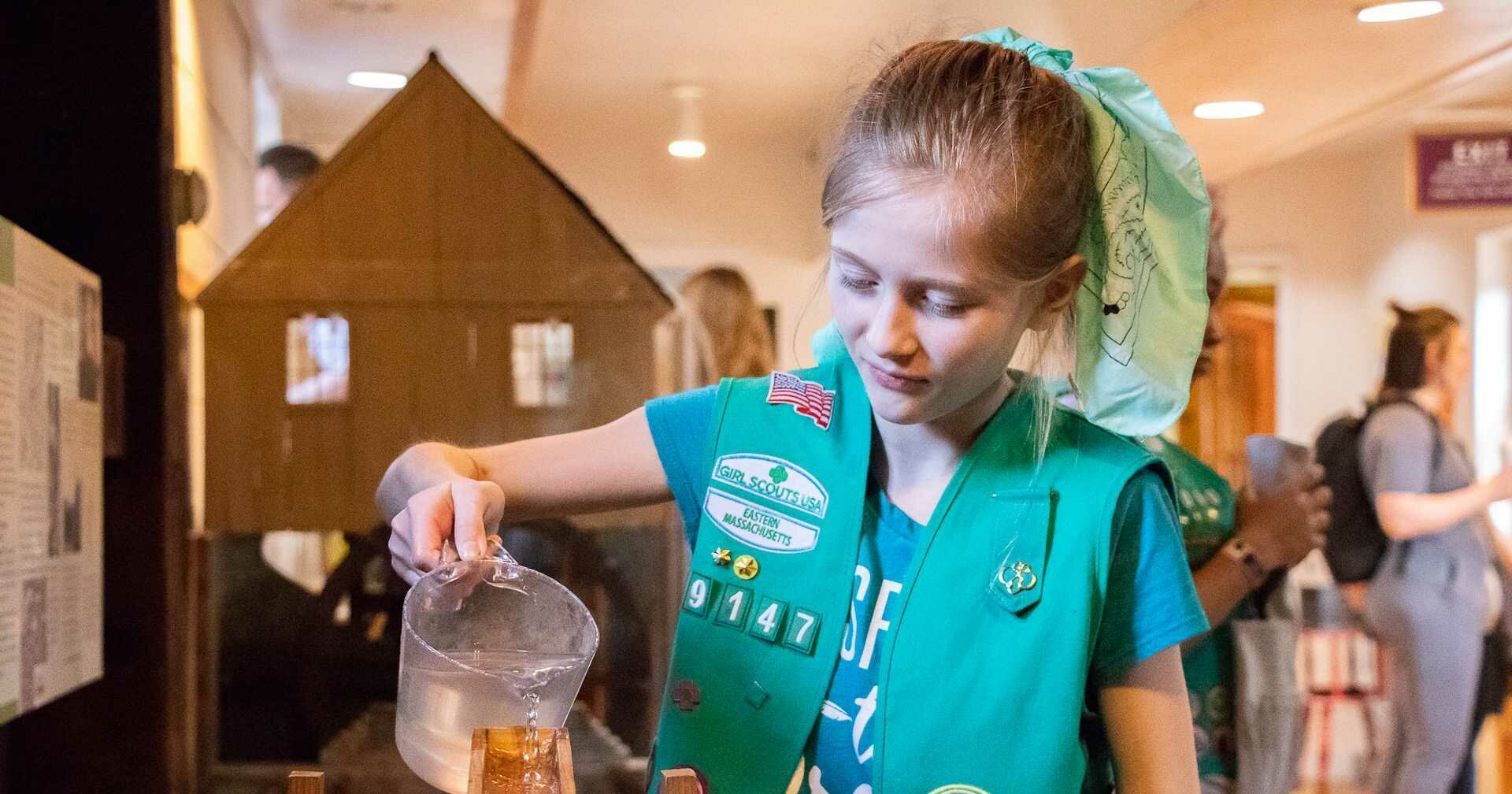 Scout pours water in educational activity