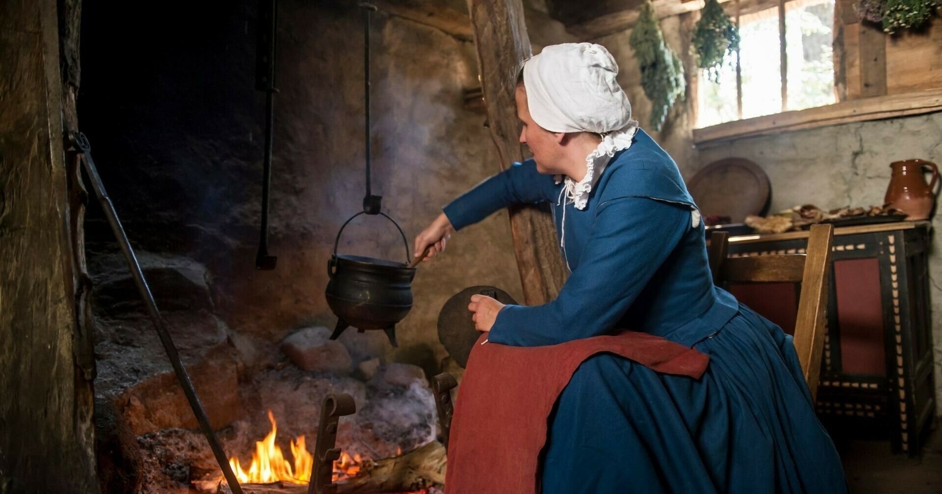 Pilgrim woman cooks over fire