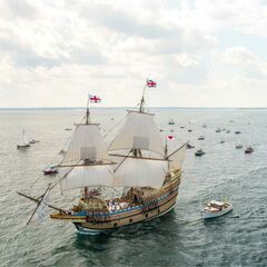 Mayflower ii under sail with several boats around her