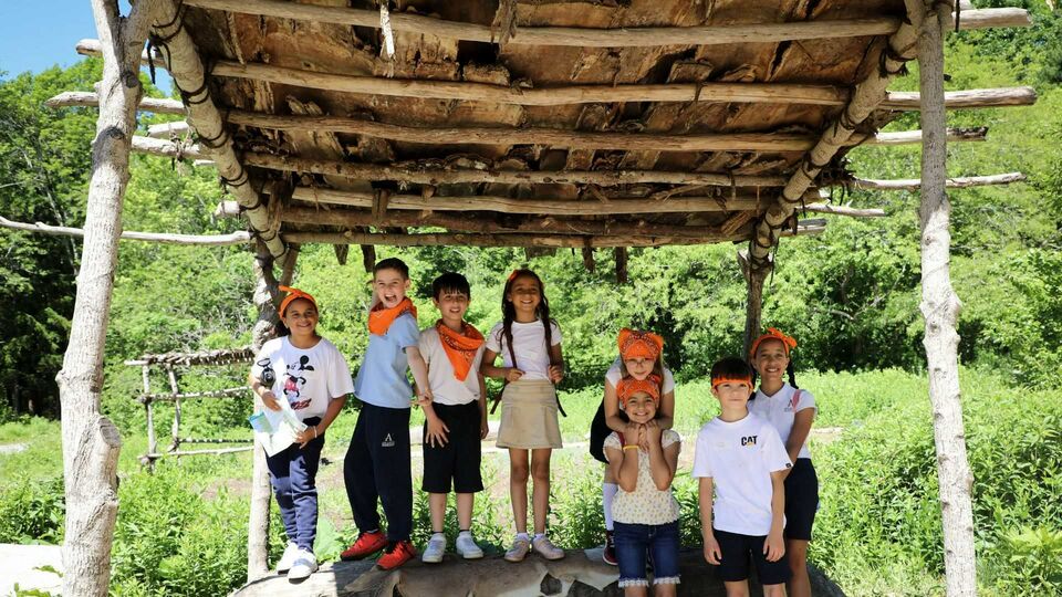 Multiple school children under outdoor arbor on Historic Patuxet Homesite
